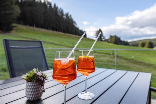 zwei Weingläser auf einem Holztisch in der Unterkunft Apartment Hiesle in Sankt Georgen im Schwarzwald