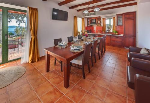 a dining room with a table and chairs and a kitchen at Villa Primorje in Biograd na Moru