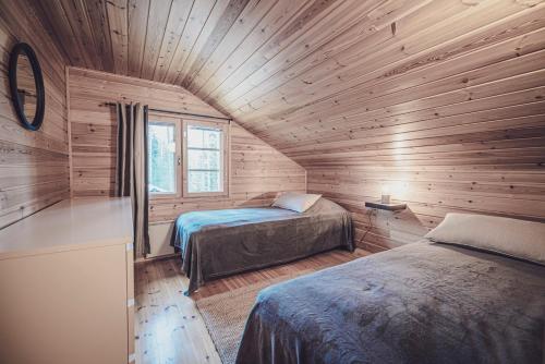 una camera con due letti in una baita di legno di Rock and Lake a Harjunmaa