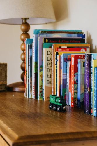 a toy truck sitting on top of books on a table at Gorgeous English Farmhouse Holiday Cottage for 9 and a half in Ellingham