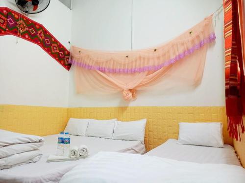 Habitación con 2 camas y cortina en la pared en Mai Tiến homestay 188, en Mai Chau