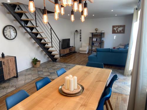 - un salon avec une table en bois et des chaises bleues dans l'établissement Maison 4 Chambres avec Piscine, à Estillac