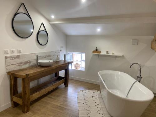 EstillacにあるMaison 4 Chambres avec Piscineのバスルーム(バスタブ、洗面台、鏡付)