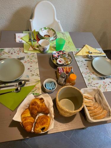 a table with bread and pastries and plates on it at B&B Il Castellaccio - Albavilla in Albavilla
