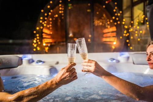 two people holding champagne glasses in a bathtub at Musala Hotel in Borovets