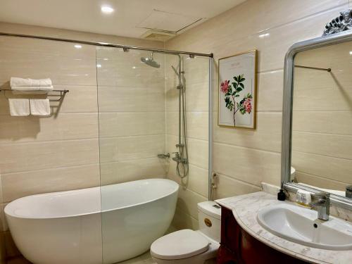 a bathroom with a tub and a toilet and a sink at Khách sạn Sa Chi - Móng Cái in Móng Cái