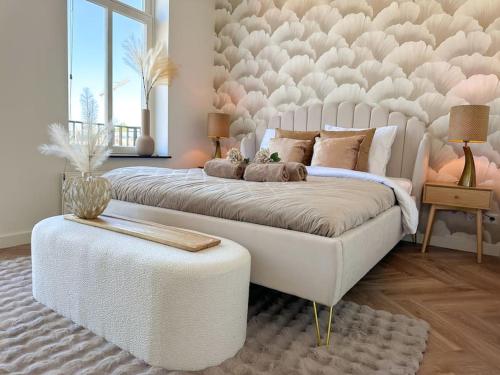 a bedroom with a large white bed with a tufted headboard at Cooth's Residence in Breda