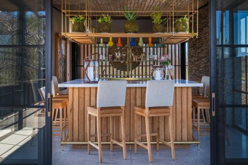 a wooden bar with chairs and plants on it at Elephant Point in Skukuza