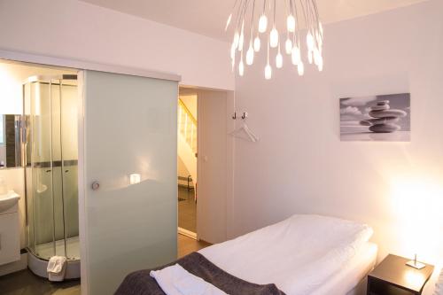 a bedroom with a bed and a chandelier at Kósý Vík in Vík