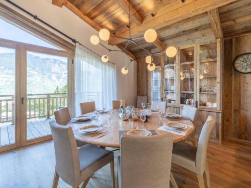 une salle à manger avec une grande table et des chaises en bois dans l'établissement Chalet familial avec SPA et sauna à Courchevel, proche de la télécabine et des commodités. - FR-1-568-36, à Courchevel
