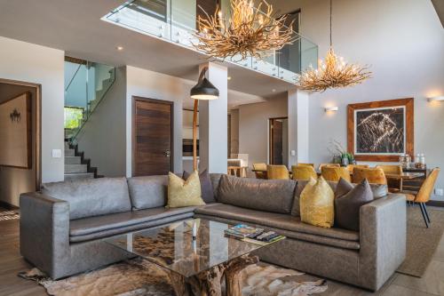 a living room with a couch and a glass table at Elephant Point in Skukuza