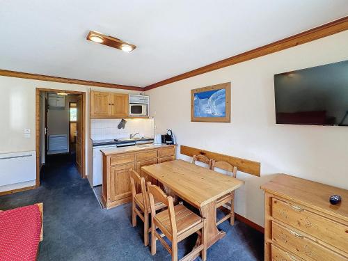 une cuisine avec une table en bois et une salle à manger dans l'établissement Appartement 2 pièces 4 pers, exposé sud, à côté télécabine des Bruyères - FR-1-178-376, aux Bruyères