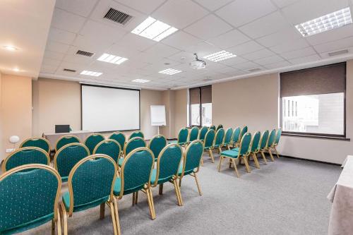 a conference room with green chairs and a podium at Best Western Plus Atakent Park Hotel in Almaty