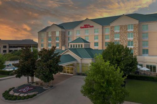 a rendering of a hotel building with trees in front at Hilton Garden Inn Frisco in Frisco