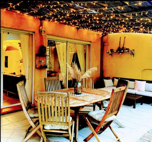 une salle à manger avec une table et des chaises dans l'établissement La Maison de Coco 120m2 à 400 m de la plage, à La Londe-les-Maures