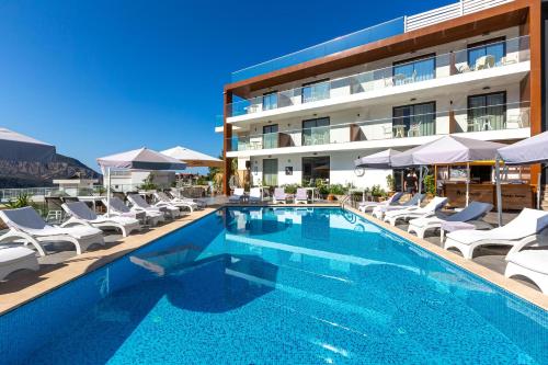 a swimming pool with lounge chairs and a hotel at Rhapsody Hotel & Spa Kalkan in Kalkan
