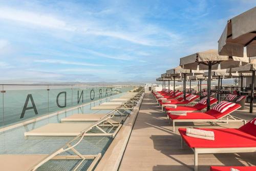 a row of lounge chairs and umbrellas on the beach at Pure Salt Garonda - Adults Only in Playa de Palma