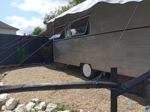 une remorque est attelée à une clôture dans l'établissement Caravane vintage avec spa, à Saint-Aignan
