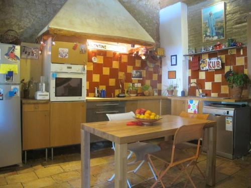 une cuisine avec une table avec un bol de fruits dessus dans l'établissement Grande maison pour vacances en famille, à Salvagnac