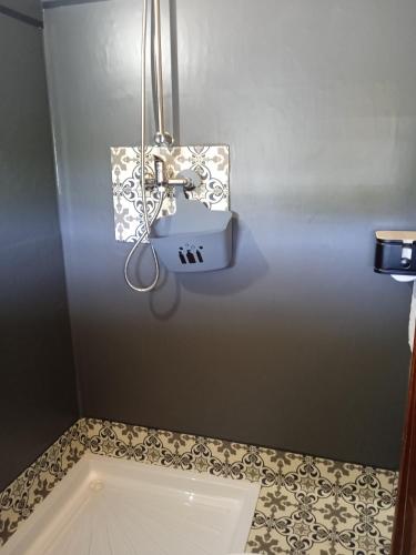 La salle de bains est pourvue d'un lavabo et de carrelage. dans l'établissement Caravane vintage avec spa, à Saint-Aignan