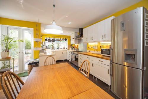 a kitchen with a wooden table and a refrigerator at The Green House Guest House in Liverpool