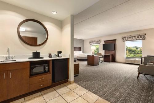 a hotel room with a sink and a living room at Hampton Inn & Suites Pittsburgh Waterfront West Homestead in West Homestead