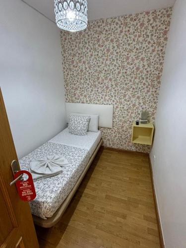 a small bedroom with a small bed with a chandelier at Hostal New Dream Madrid in Madrid
