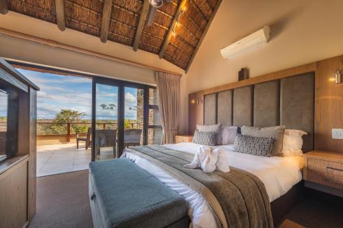 a bedroom with a large bed and a balcony at Elephant Point in Skukuza