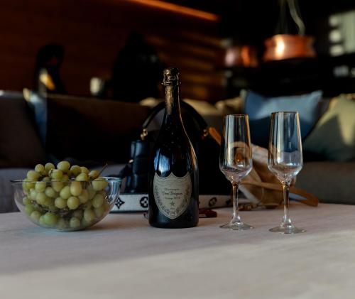 een fles wijn en twee wijnglazen op een tafel bij The Ski Room Sierra Nevada in Sierra Nevada