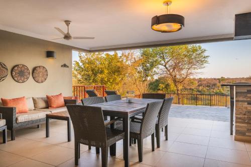 a dining room with a table and chairs and a couch at Elephant Point in Skukuza