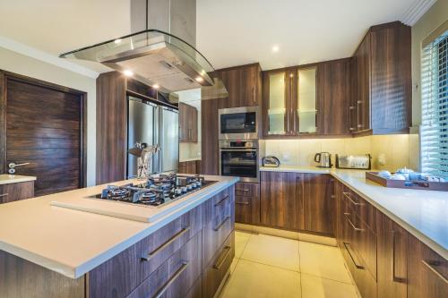 a kitchen with wooden cabinets and a stove top oven at Elephant Point in Skukuza