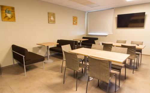 a dining room with tables and chairs and a tv at Everest Kivioli Hostel in Kiviõli