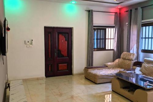 a living room with a couch and a wooden door at Appartement de haut standing in Rhodan