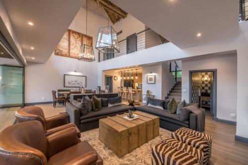 a living room with couches and a table at Elephant Point in Skukuza