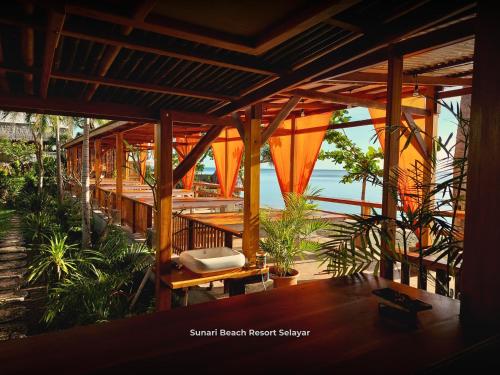 a porch of a resort with a bench and plants at Sunari Beach Resort Selayar - Real in Pareangang