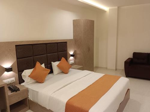 a bedroom with a large bed with orange pillows at Hotel Metro Inn in Mumbai