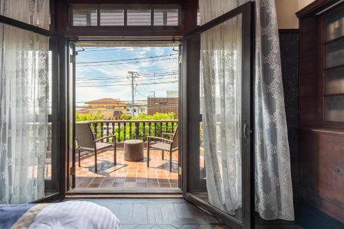 a bedroom with a door open to a balcony at Shinoda House in Kamakura