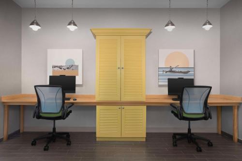 an office with a yellow desk and two chairs at Home2 Suites by Hilton Eugene Downtown University Area in Eugene