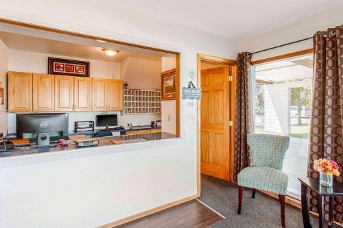 a kitchen with wooden cabinets and a table and a chair at Rodeway Inn Coeur d'Alene in Coeur d'Alene