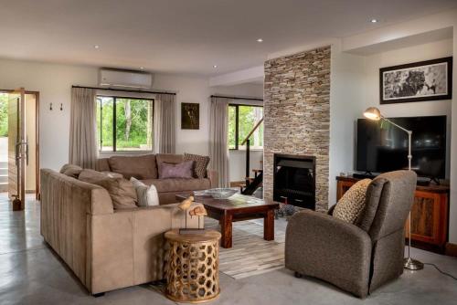 a living room with a couch and a fireplace at Elephant Point in Skukuza