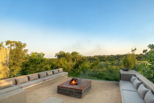 a living room with a couch and a fire pit at Elephant Point in Skukuza