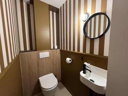 a bathroom with a toilet and a sink and a mirror at Au refuge de la colline Ecolodge 4 étoiles avec vue magnifique sur la vallée, proche de Mers les bains in Longroy
