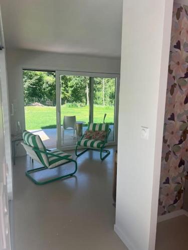 a hallway with three chairs and a room with windows at Au refuge de la colline Ecolodge 4 étoiles avec vue magnifique sur la vallée, proche de Mers les bains in Longroy