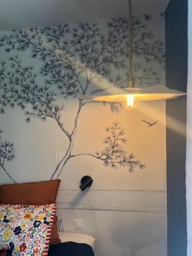 a wall with a mural of a tree and birds at Au refuge de la colline Ecolodge 4 étoiles avec vue magnifique sur la vallée, proche de Mers les bains in Longroy
