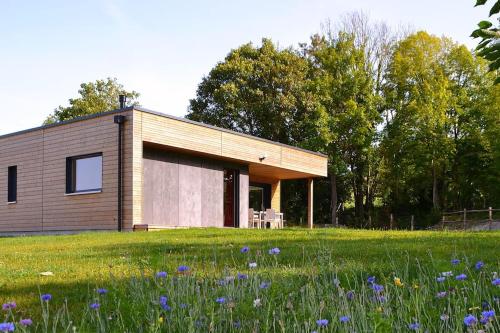 a small wooden house in a field of flowers at Au refuge de la colline Ecolodge 4 étoiles avec vue magnifique sur la vallée, proche de Mers les bains in Longroy