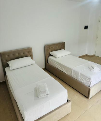 two beds sitting next to each other in a room at Vila TOLA in Durrës