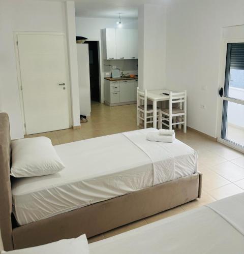 a large bed in a room with a kitchen at Vila TOLA in Durrës