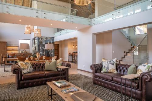 a living room with leather couches and a table at Elephant Point in Skukuza