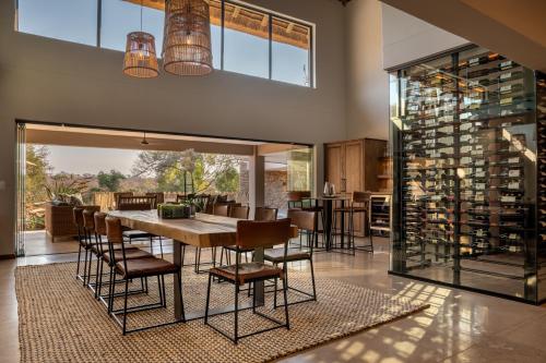 a dining room with a table and chairs and a wine cellar at Elephant Point in Skukuza