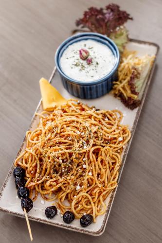 a plate of spaghetti and blueberries and a bowl of dip at Taksim REXXEE Istanbul Istiklal Hotel in Istanbul